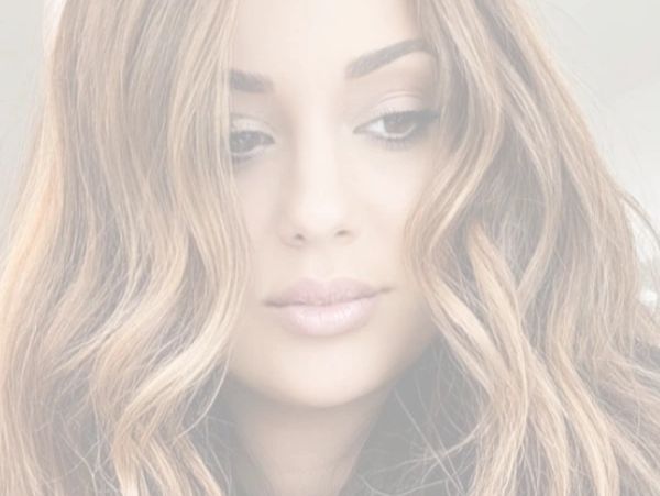 Close-up of a woman with long wavy hair and natural makeup.