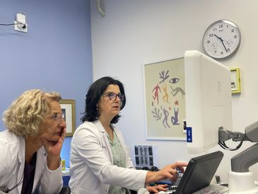 Two female doctors analyzing medical images on a computer.