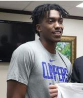 Young man wearing a Clippers shirt indoors.