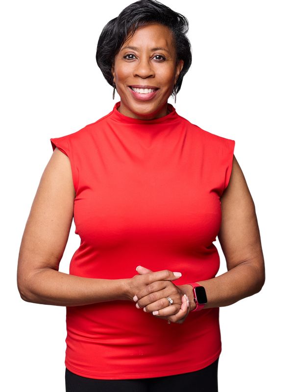 Picture of Dr. Paula C. Perez with a red top standing with her hands clasped in front of her.