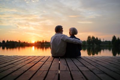 Two people sitting on a boat dock