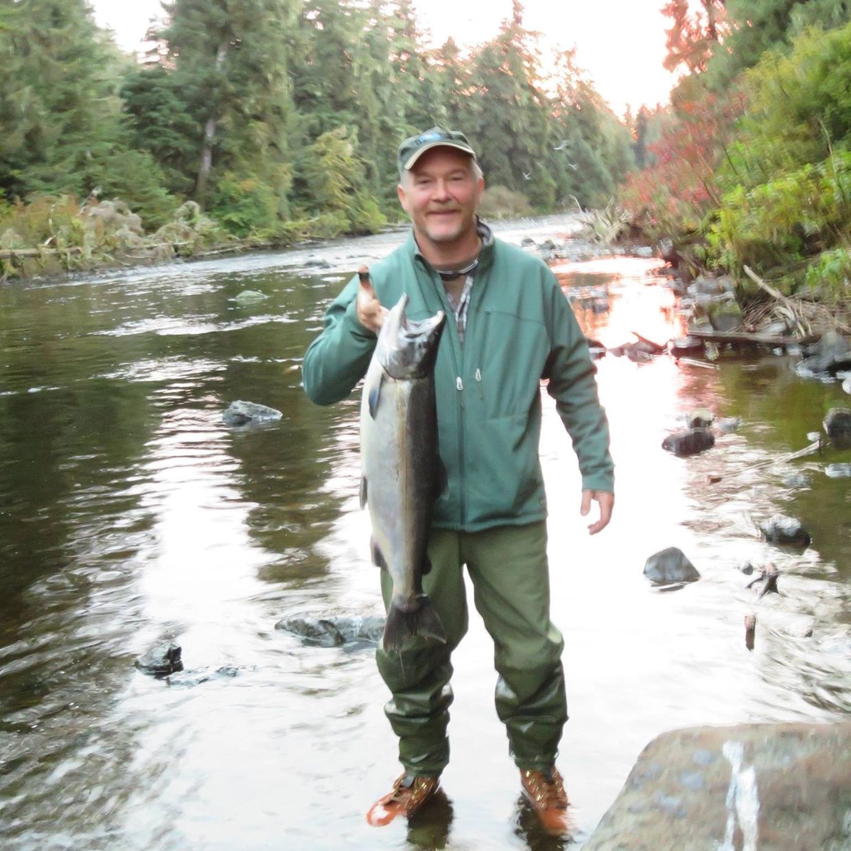 a man wearing a cap is holding a fish 