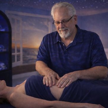 Therapist performing knee massage on a client in a serene room.