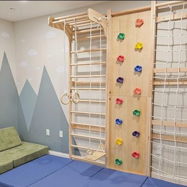 Indoor wall gym for kids including ropes, rock climbing, ladder, and pull up rings