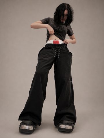 Person wearing oversized black pants and platform shoes.