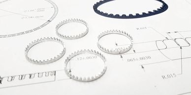 Mechanical gear components placed on a technical drawing sheet.