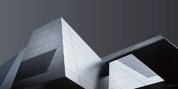 Modern angular building with reflective panels under a dark sky.