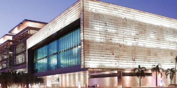 Modern building with illuminated facade and large glass windows at dusk.