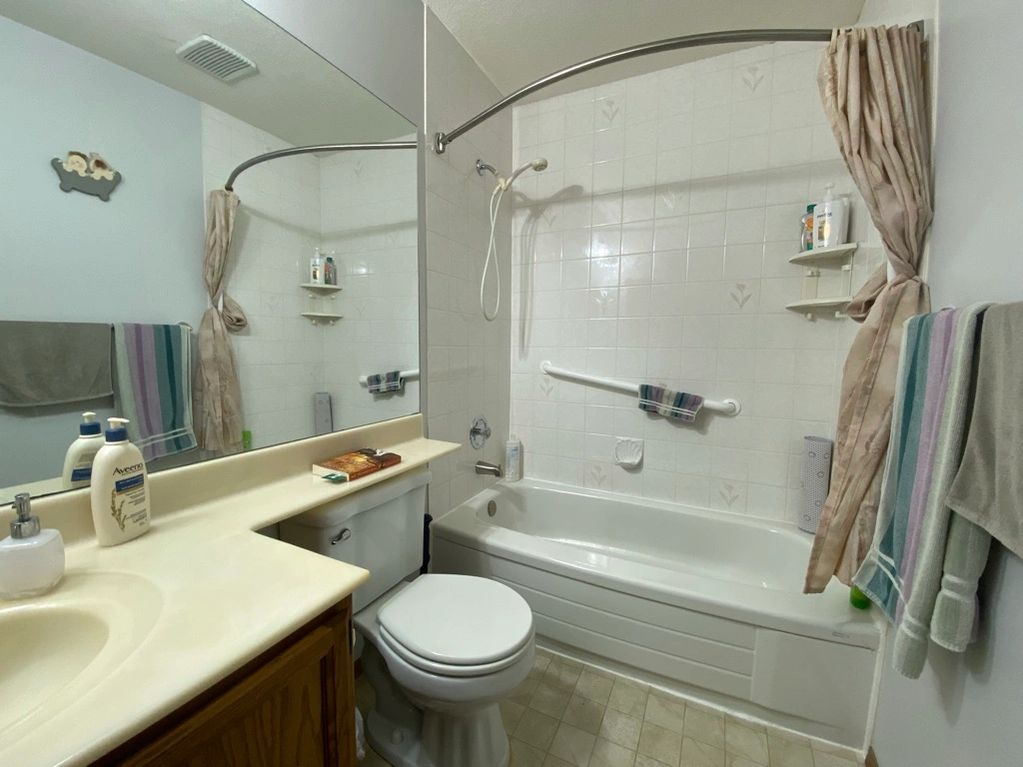70's era original bathroom with 6x6 tile, metal tub and a counter banjo.