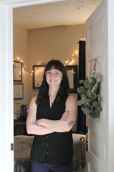 Woman standing in a decorated room doorway.