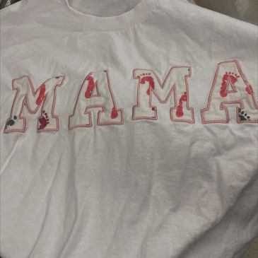 White shirt with "MAMA" and baby footprints design.