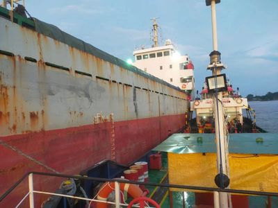 Two ships docked closely together during early evening.