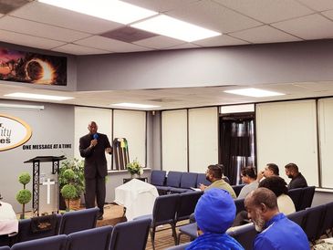 A preacher speaks to a congregation at Impact Community Ministries.