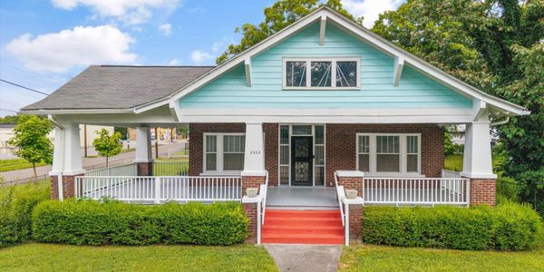 Charming bungalow with turquoise siding and broad front porch.
