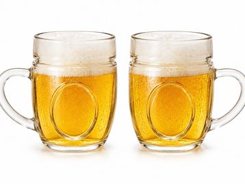 Duas canecas de cerveja com espuma.