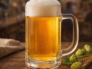 Caneca de cerveja gelada com espuma.