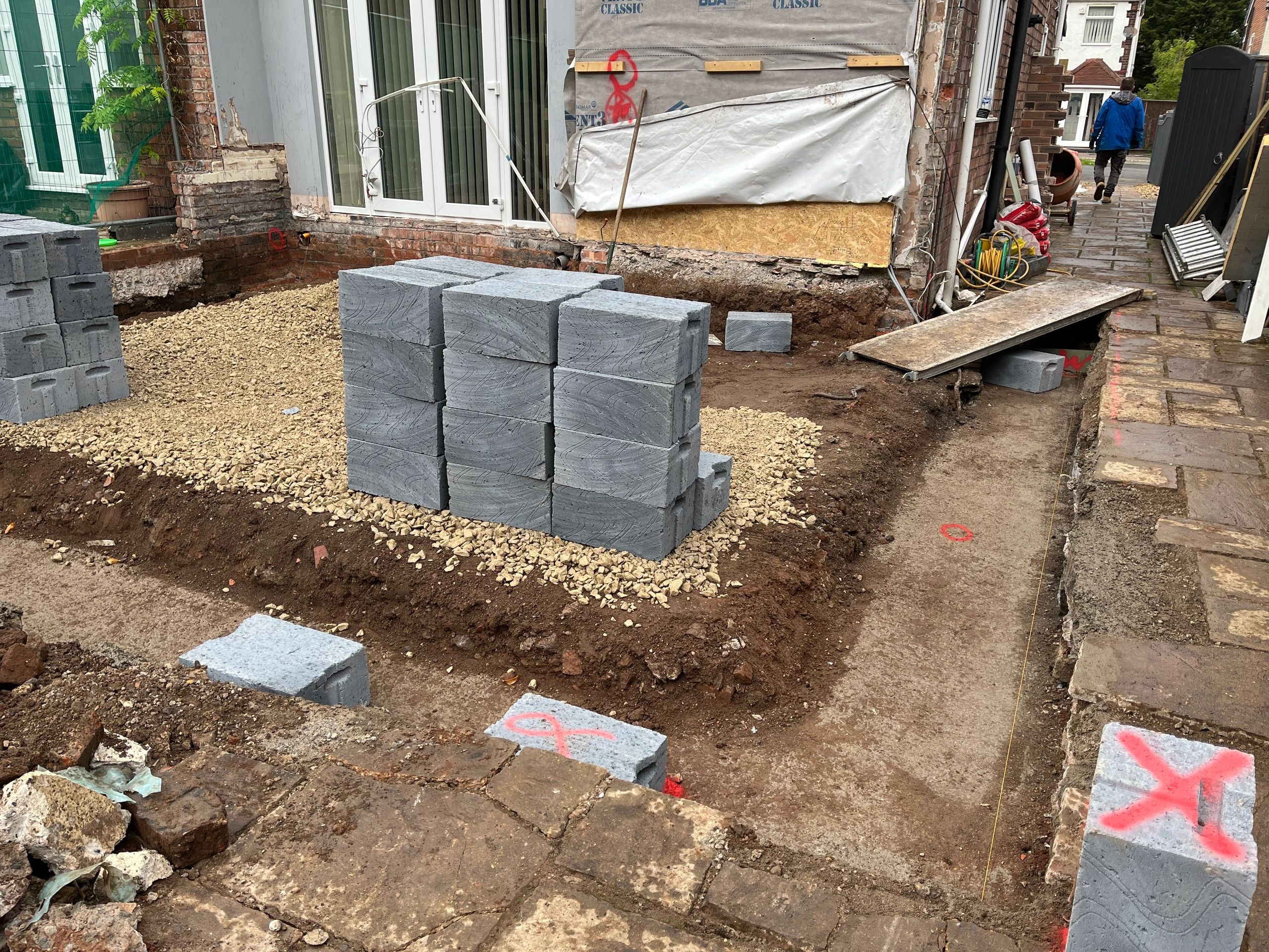 Construction site with stacked concrete bricks and foundation preparation
