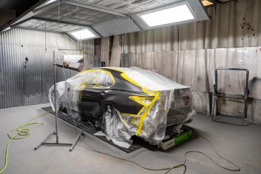 Car being painted in a workshop.