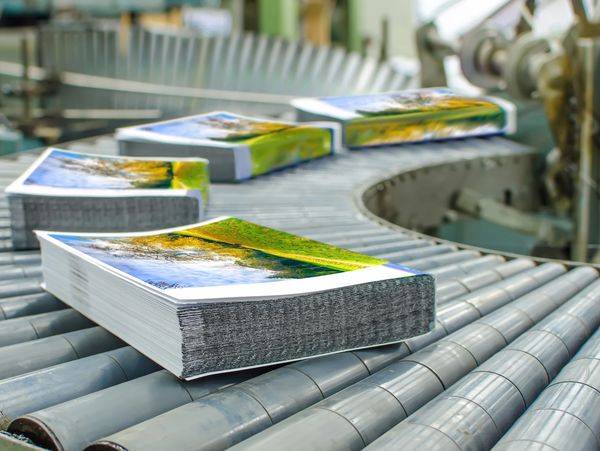 Printed booklets moving along a conveyor belt.






