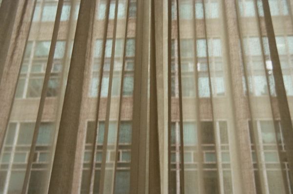 Sheer curtains with a building visible through them.