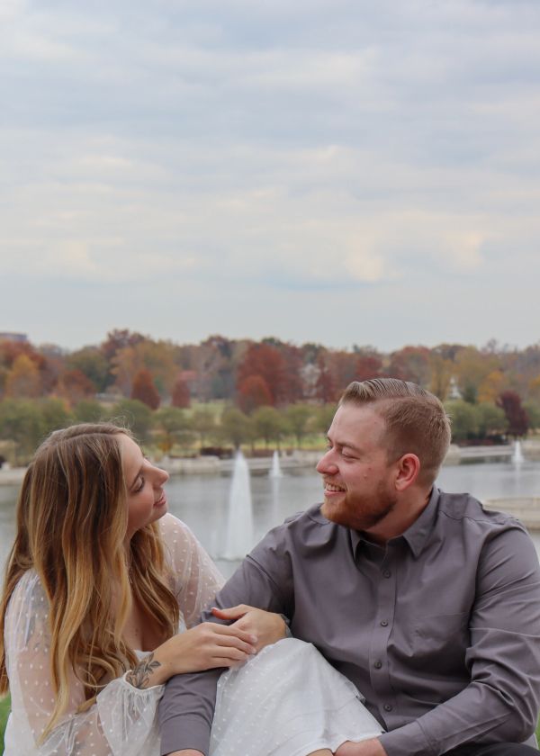 Couple sharing a happy moment by the water with fountains.
