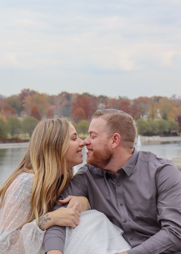 Couple gazing lovingly by the water.
