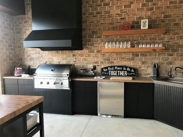 Outdoor kitchen with black grooved door/drawer fronts