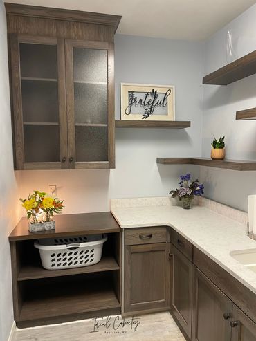 Hamper storage with matching stained hickory wood top and glass doors above in upper cabinet