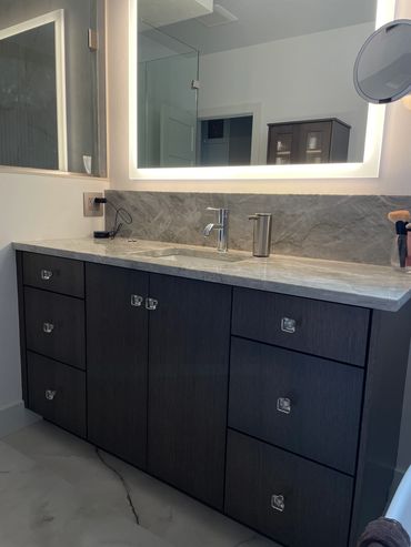 Custom stained white oak frameless vanity with glass knob hardware