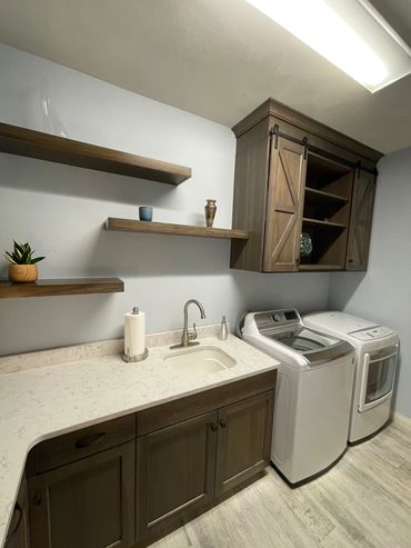 Hickory cabinetry with sliding barn doors and staggered floating shelves