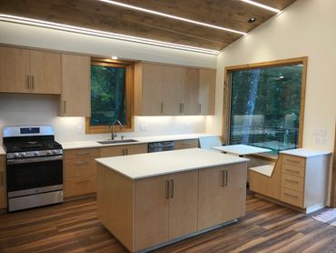 Frameless clear stained maple kitchen with seat-in nook overlooking a view