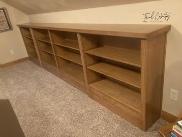 Narrow depth bookcase cabinetry with routed out toe kick for heat vent