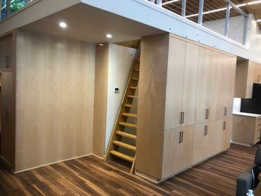 Living room built-ins with closed wine bar storage and custom paneled matching wood wall 