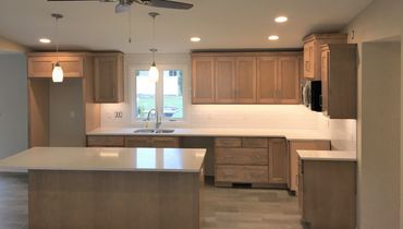 Stained maple cabinetry going to vaulted kitchen ceiling and new countertops