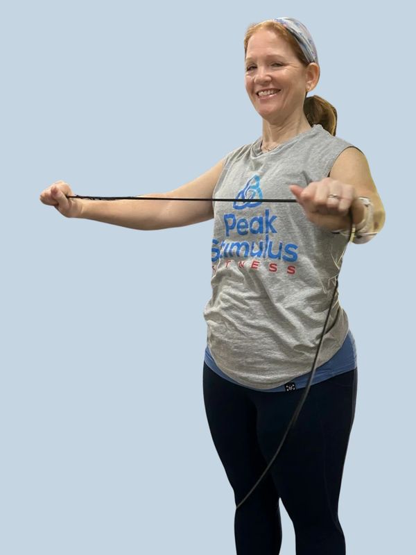 Woman smiling while exercising with a resistance band.