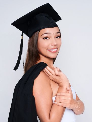 Young woman smiling in graduation attire.