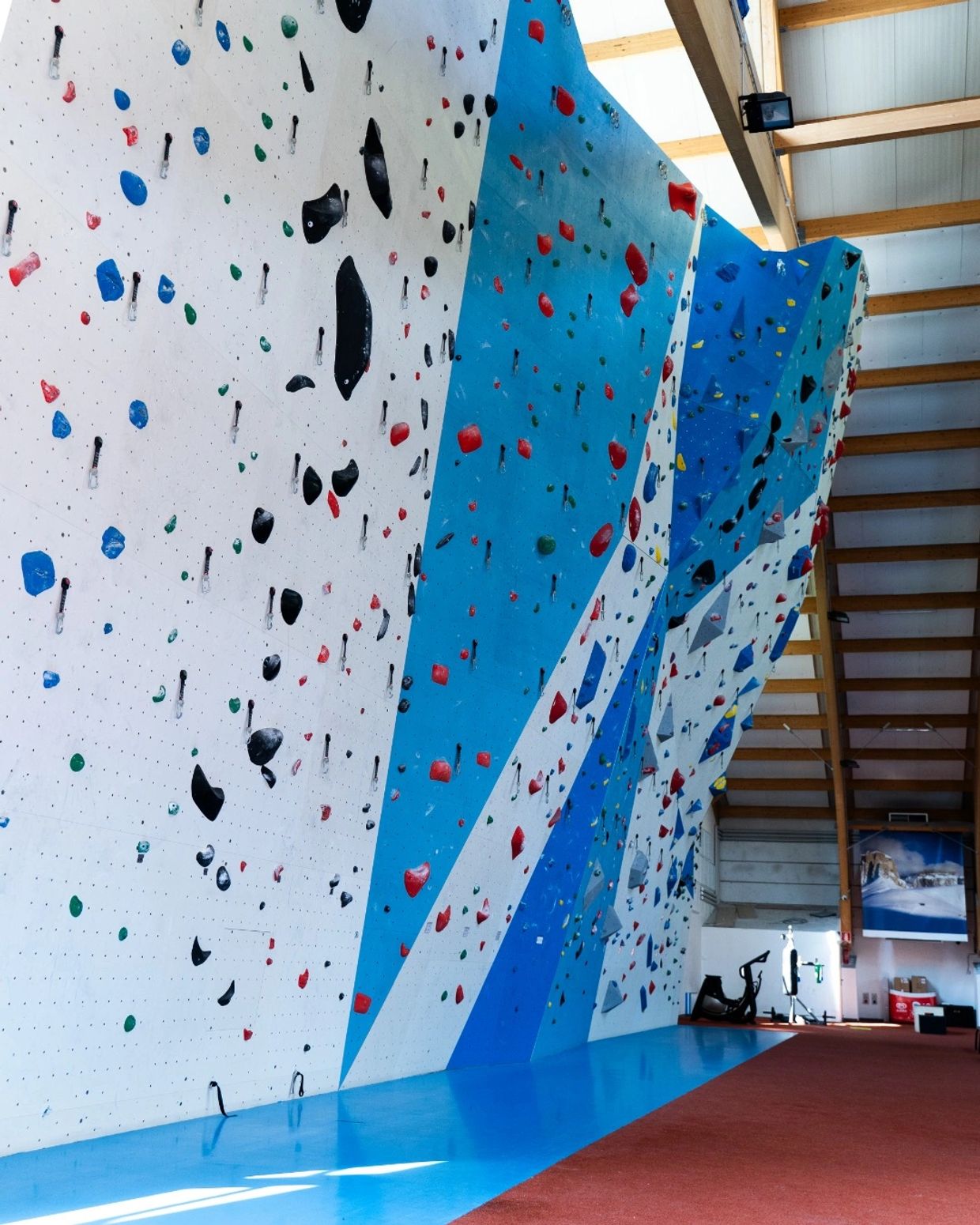 Indoor climbing gym with colorful climbing holds on angled walls.