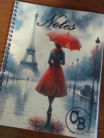 Notebook cover with a woman in red and Eiffel Tower in rainy Paris.