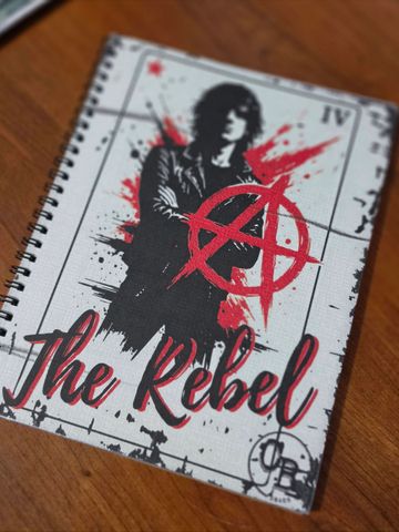 Notebook cover featuring a rebellious figure with an anarchy symbol and 'The Rebel' text.