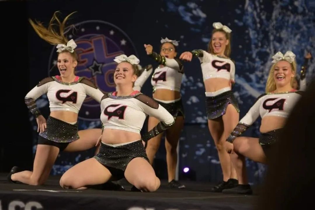 Cheerleaders performing an energetic routine on stage.