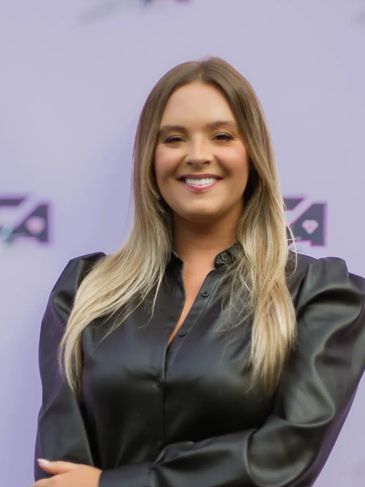 Smiling woman in black leather outfit.