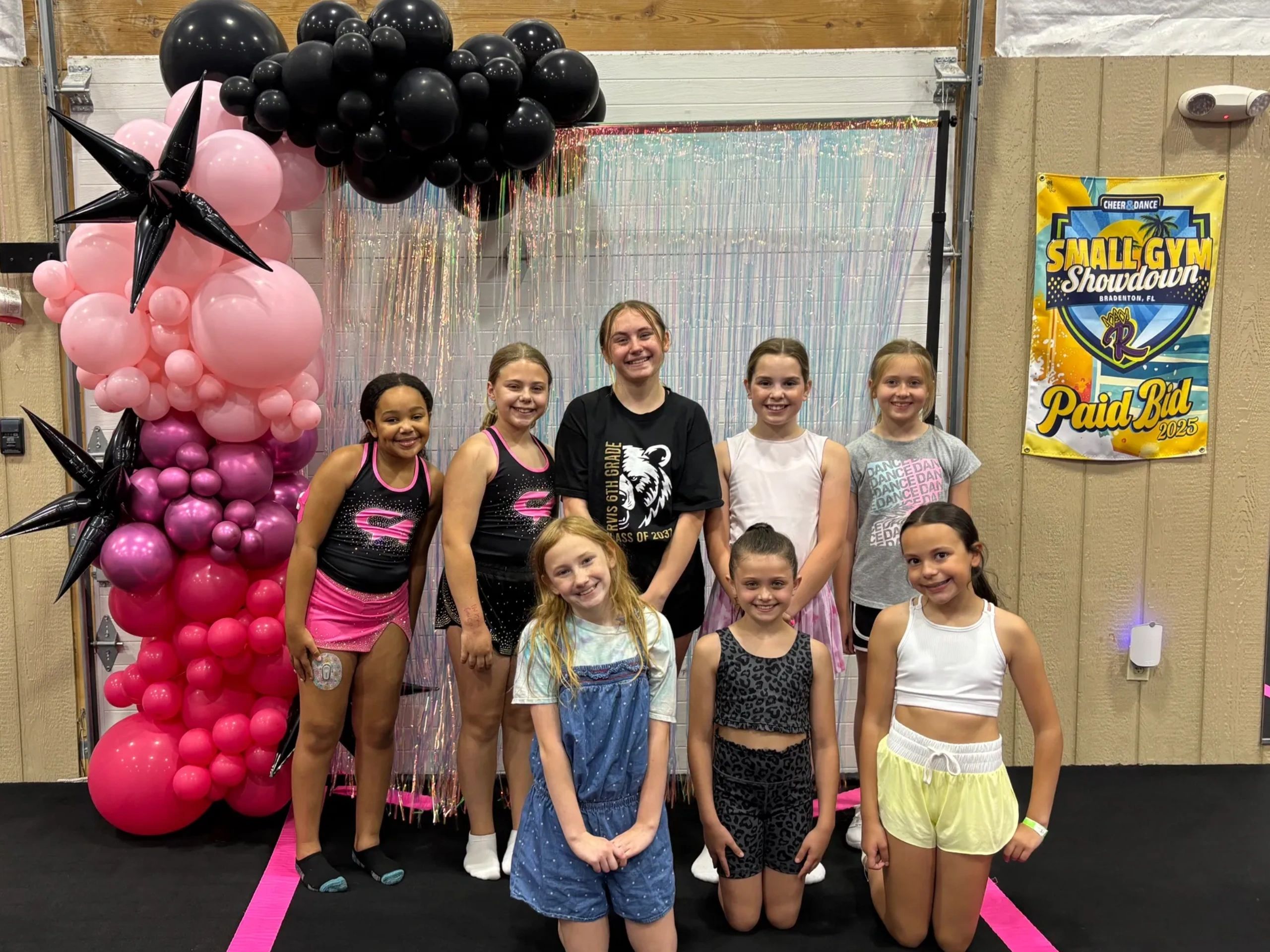 Group of smiling girls at a cheer and dance event.