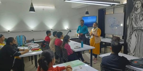 A classroom session with students and two instructors. 