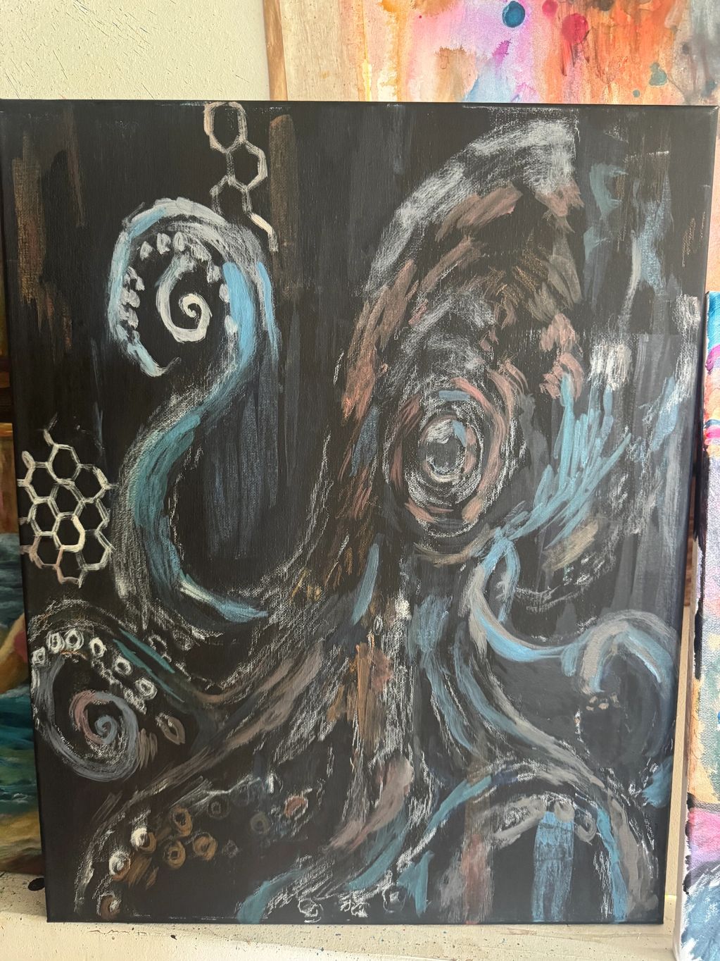 Abstract octopus painting with swirling tentacles on dark background.