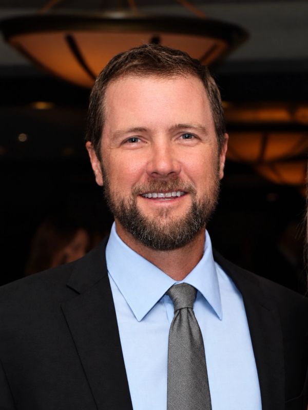 Smiling man in suit and tie.