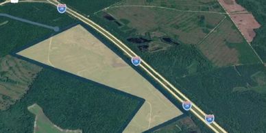 A highway running through green and brown fields.
