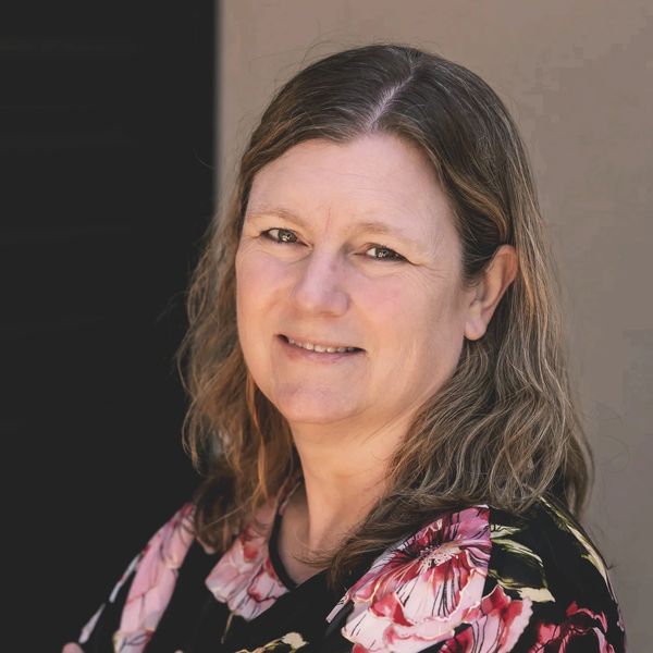 Portrait of a middle-aged woman smiling.