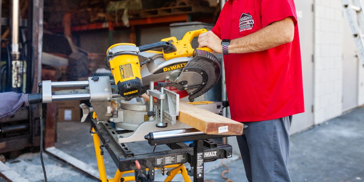 Person cutting wood with a DeWalt miter saw.