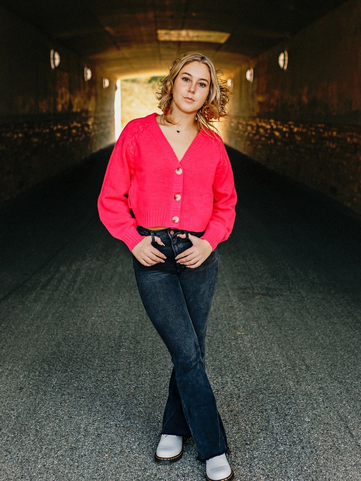 a woman wearing a pink top and black jeans 