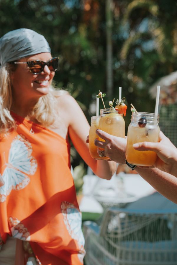 lady cheers while holding sangria and celebrating with friends on lido beach Florida.